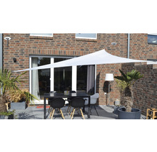 Terras met zonnescherm, tafel en stoelen voor een bakstenen huis