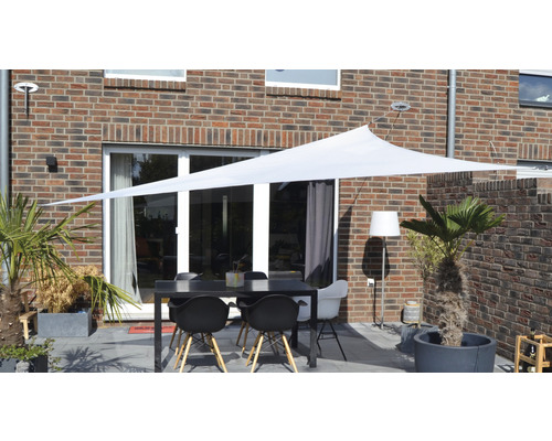 Terras met zonnescherm, tafel en stoelen voor een bakstenen huis