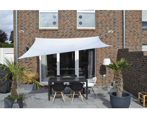 Terras met zonnescherm, tafel en stoelen voor een huis