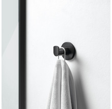 Zwarte handdoekhaak met handdoek aan de muur gemonteerd