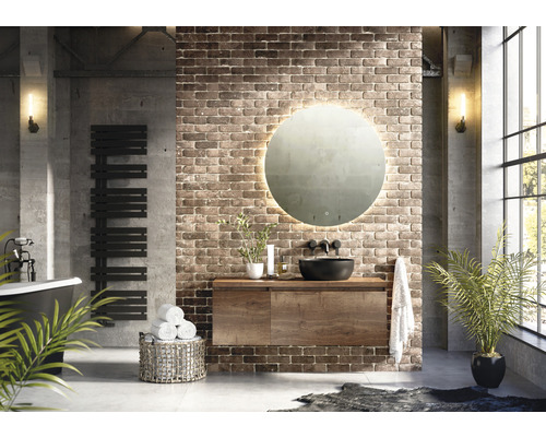 Badkamer in industriële stijl met wastafel, spiegel, radiator en bad.