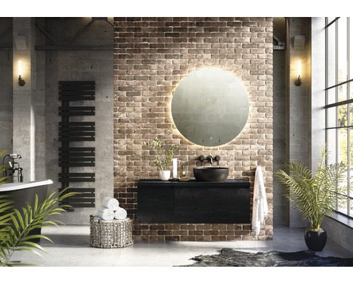 Moderne badkamer met vrijstaand bad, handdoekradiator, wastafelonderkast, ronde spiegel met verlichting en bakstenen muur