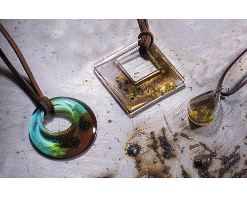 Drie halskettingen met verschillende hangers en bruine leren banden