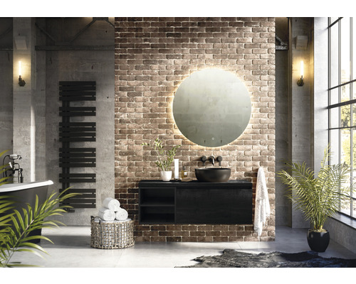 Badkamer in industriële stijl met wastafel, spiegel met verlichting en handdoekradiator.