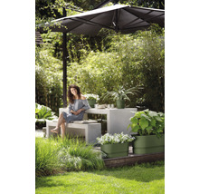 Tuinomgeving met parasol, tafel, bank en beplante bloembakken.