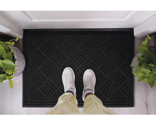 Zwarte deurmat met geometrisch patroon voor een deur