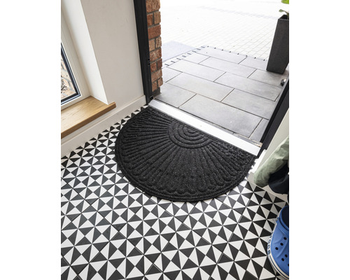 Halfronde deurmat van textiel voor een voordeur op een vloer met een geometrisch patroon