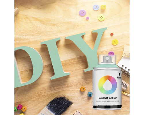 Doe-het-zelf scène met verfspuitbus, kwast en decoratieve elementen op een houten tafel