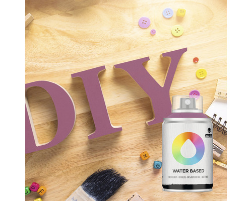 Scene met spuitverf, letters voor doe-het-zelven, penseel en knopen op een houten tafel.