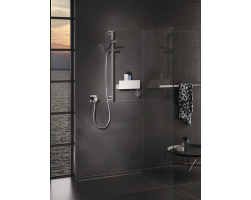 Moderne badkamer met doucheruimte, douchestang en opbergruimte voor douchebenodigdheden.