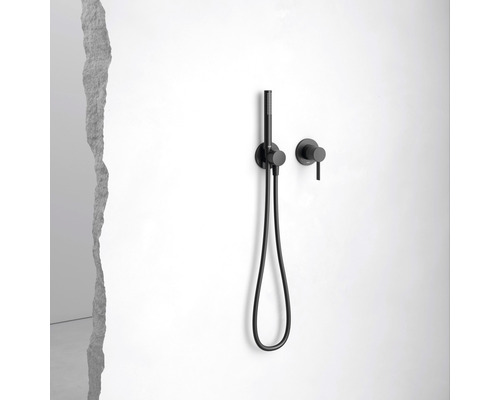 Zwarte handdouche met slang en wandarmatuur aan een witte muur