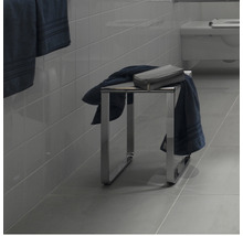 Badkamer met een metalen kruk, handdoeken en een toilettas