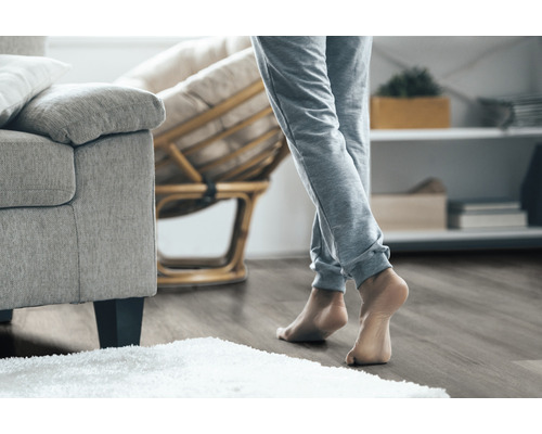 Voorbeeld van een woonkamer met houten vloer, bank en fauteuil