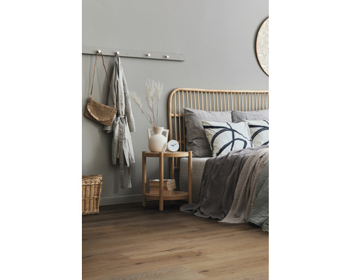 Slaapkamer met bed, nachtkastje en decoraties voor een gezellige sfeer.