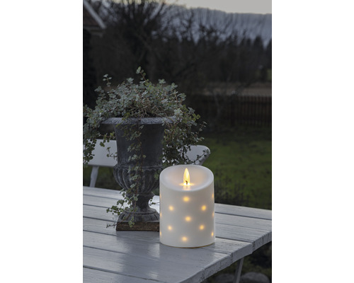 Decoratieve ledkaars met stippenpatroon op een tafel buiten