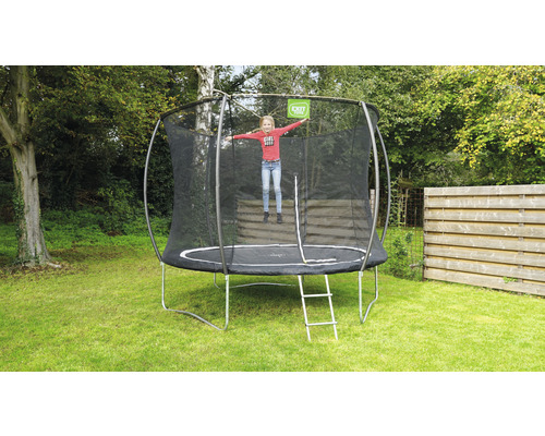 Ronde tuintrampoline met veiligheidsnet en ladder in de tuin met springend kind