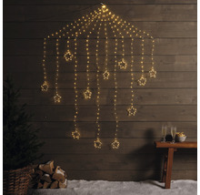 Decoratieve lichtslinger met sterren voor een houten wand, met boom, houtblokken en champagneglazen