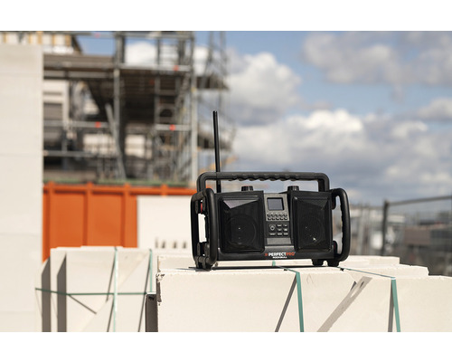 Bouwradio op metselwerk met bouwsteiger op de achtergrond