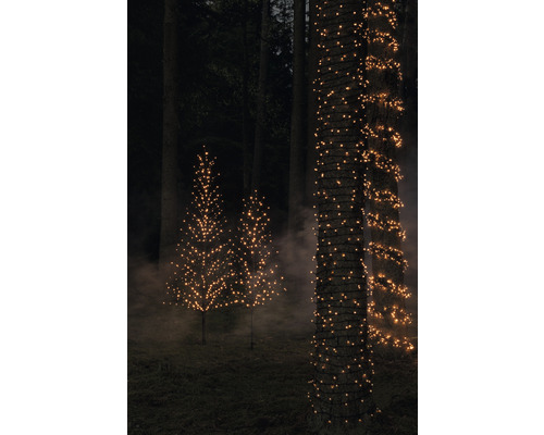 Decoratieve bomen en boomstammen met lichtslingers in de tuin