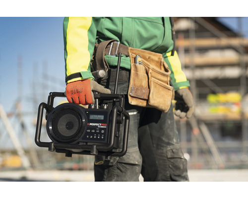 Vakman houdt een bouwradio van het merk Perfectpro vast.