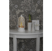 Decoratieve scène met sneeuwbol, plant, kabouter en cadeau op een tafel