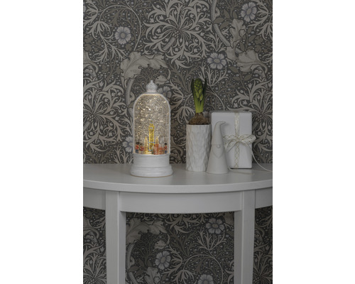 Decoratieve scène met sneeuwbol, plant, kabouter en cadeau op een tafel