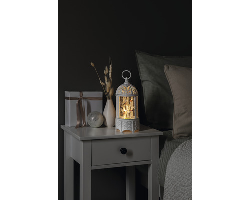 Decoratief nachtkastje met cadeau, vaas, decoratieve bal en verlichte sneeuwbol