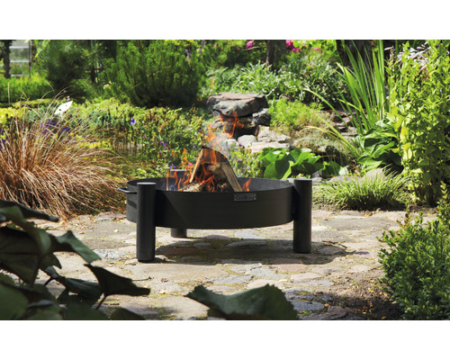 Vuurplaats met brandend hout in de tuin