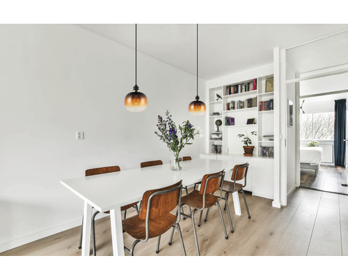 Lichte eetkamer met eettafel, houten stoelen en hanglampen