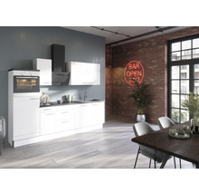 Moderne keuken met inbouwapparatuur, gootsteen en eettafel in een loftachtige ruimte met bakstenen muur