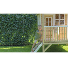 Kinderen spelen in een houten speelhuis in de tuin.
