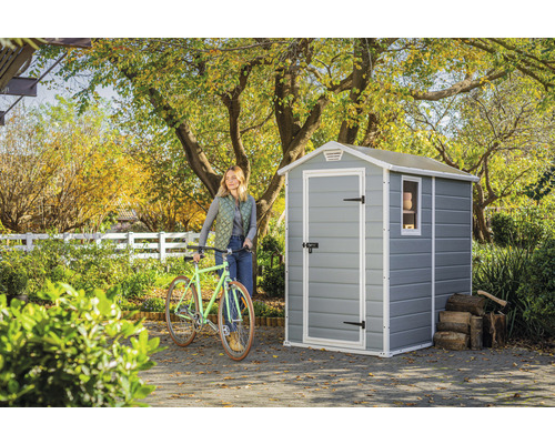 Tuinscène met tuinhuis, fiets en vrouw in de tuin