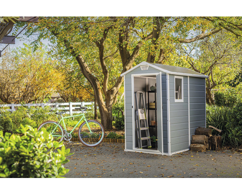 Tuinscene met tuinhuis, fiets, ladder, rek en stapel hout