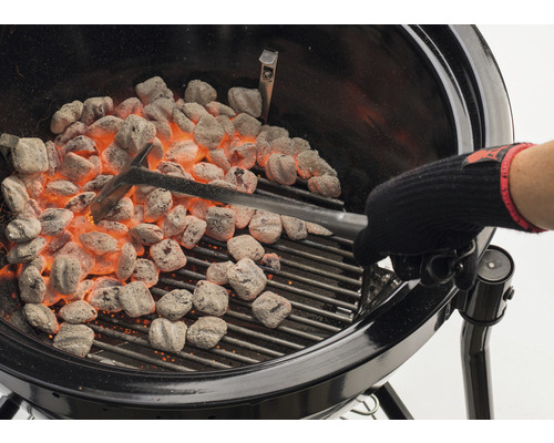 Barbecue met gloeiende briketten en barbecuegereedschap