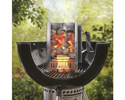 Aansteker met gloeiende grillbriketten op een houtskoolgrill