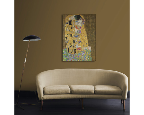 Schilderij ''De Kus'' van Gustav Klimt boven bank met vloerlamp