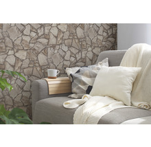 Woonkamer met stenen muur, bank, kussens, deken en beker