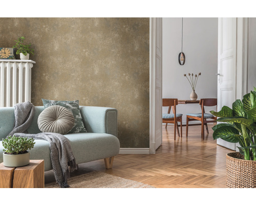 Woonkamer met beige structuurbehang, bank, kamerplanten en houten vloer