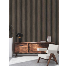 Interieur met houten wandpanelen, een dressoir, een lamp, boeken en een fauteuil.