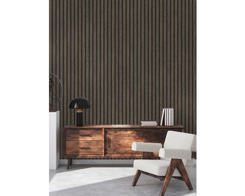 Interieur met houten wandpanelen, een dressoir, een lamp, boeken en een fauteuil.