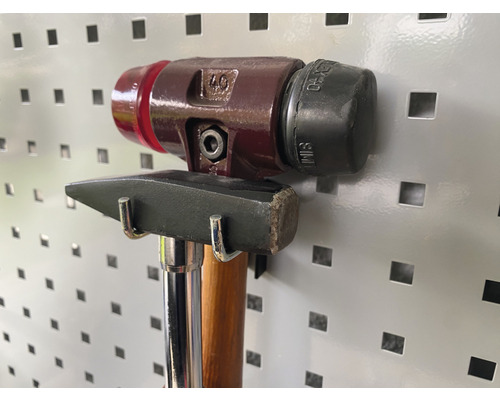 Twee hamers hangen aan een gereedschapswand.