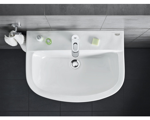 Bovenaanzicht van een wastafel met kraan, zeep en handdoeken in de badkamer