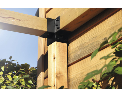 Detailopname van een houten constructie met een zwarte metalen verbinding en schroeven