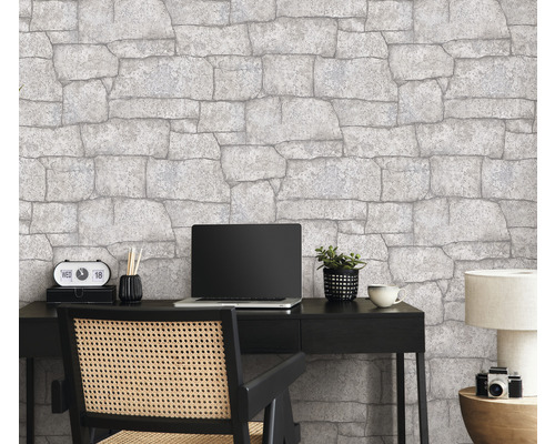 Kantoor met steenbehang, bureau, laptop en bureaustoel