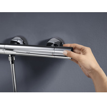 Grohe douchekraan met thermostaat en hand die de temperatuur instelt