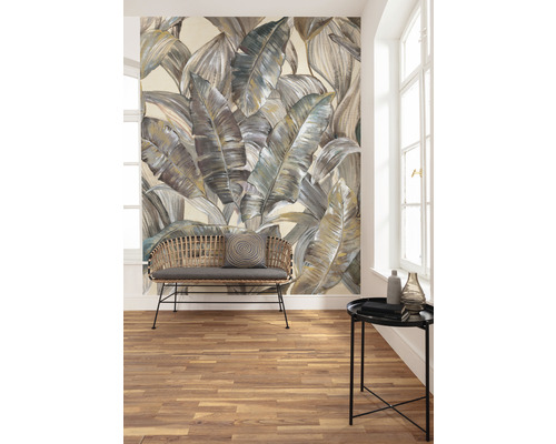 Woonkamer met een foto van een behang met bladeren, een bank en een tafel