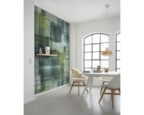 Moderne eetkamer met een behang met patroon in groen- en blauwtinten, evenals een eettafel met stoelen.