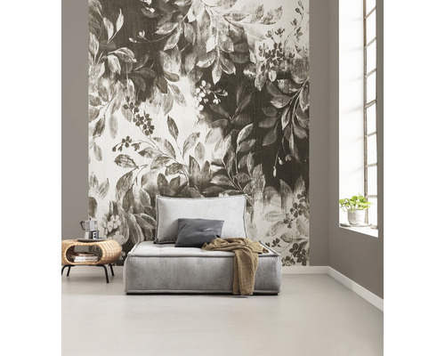 Woonkamer met fotobehang met plantmotieven, fauteuil en bijzettafel