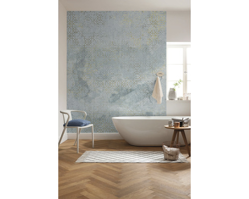 Badkamer met bad, stoel, vloerkleed, kruk en behang met patroon.