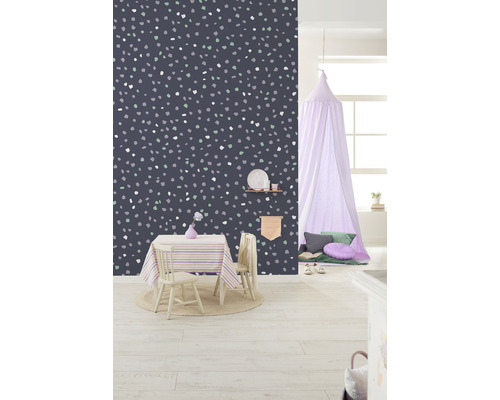 Kinderkamer met tafel, stoelen en wandbehang met stippenpatroon